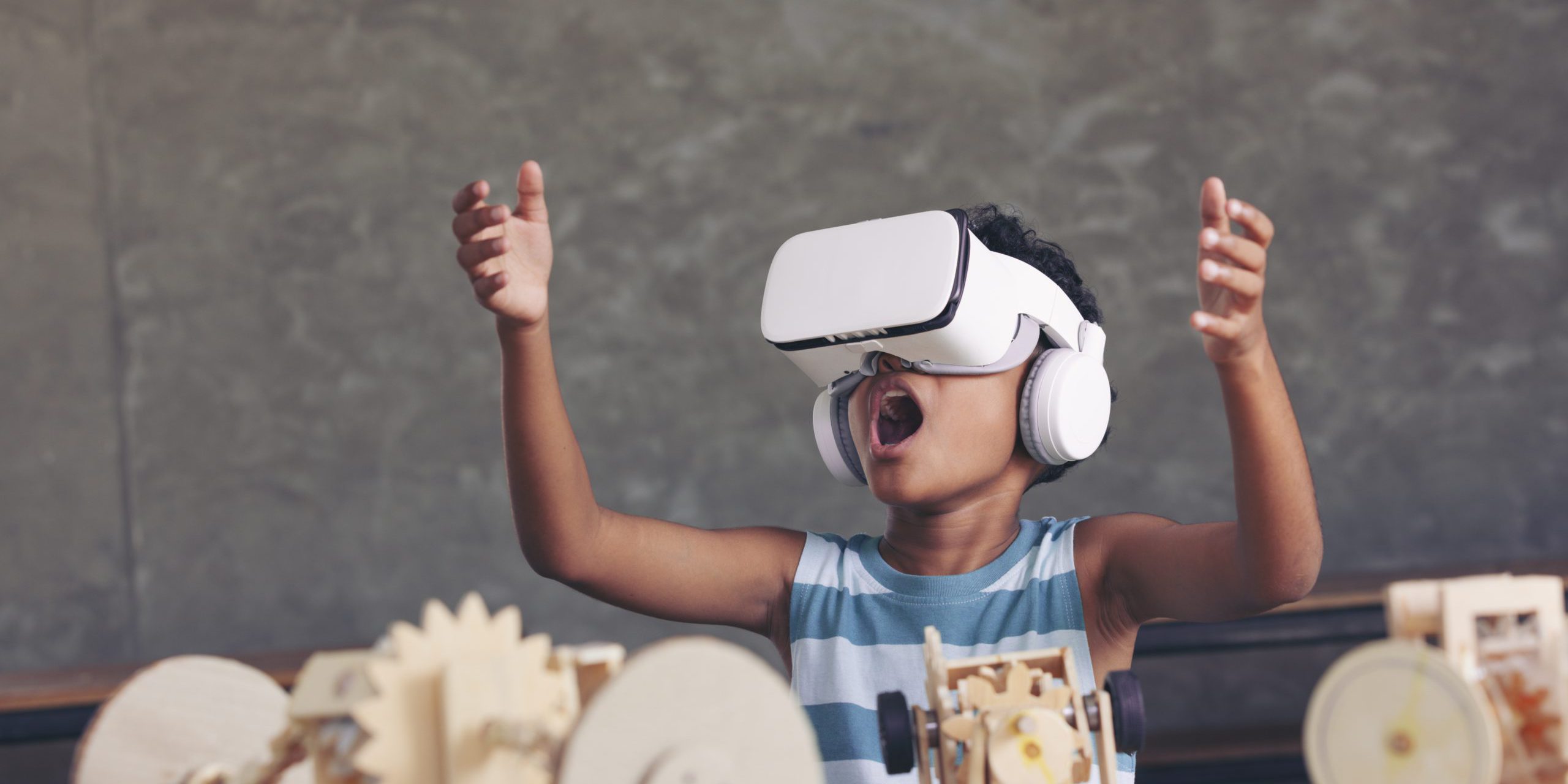 African black boy wearing 3D gadget and looking out above and having the simulation mechanism robot model wooden on table in classroom. why_and_how_to_ensure_digital_accessibility_in_education